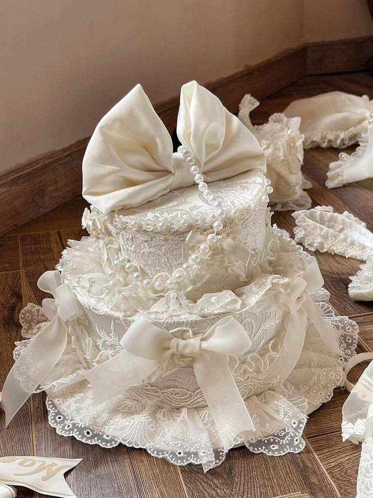 Schleifen, Perlen und verzierter Kuchenhut, cremig, wunderschön