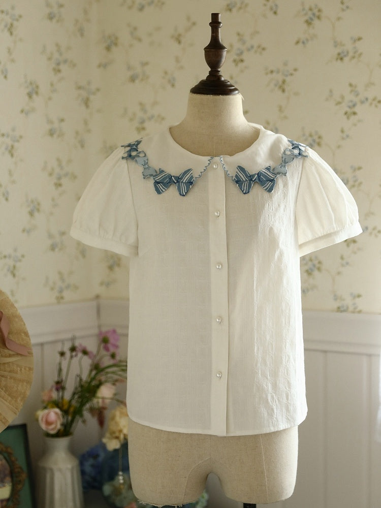 Blaue Bluse mit Schleifenbesatz und weißen Kurzarm