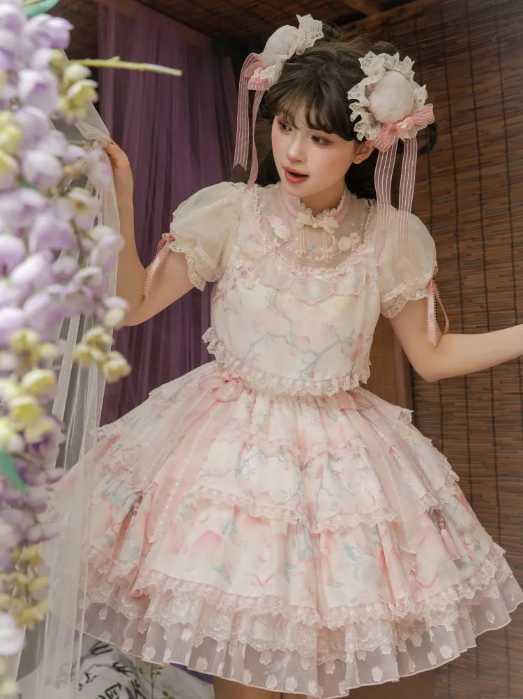 ピンクのティアードスカートQiロリータドレス。首元に繊細な桃色と桃の花の刺繍。