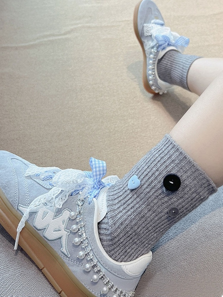 Milchweiße, süße, mit Knöpfen verzierte Wadensocken