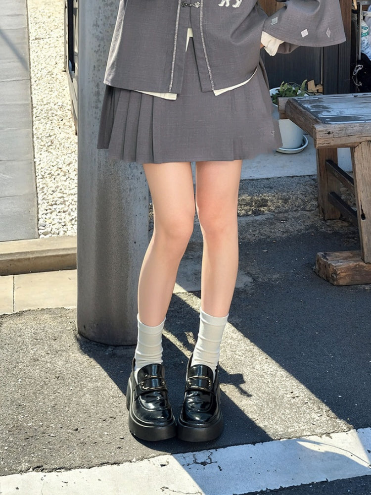 Grauer, oberschenkellanger Faltenrock mit Knotenknöpfen