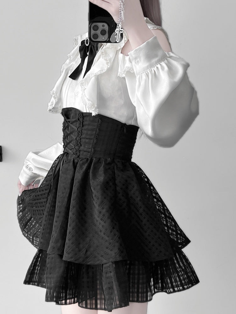 Ensemble Jirai Kei : chemisier blanc à volants et épaules découpées, jupe noire à volants et gros nœud