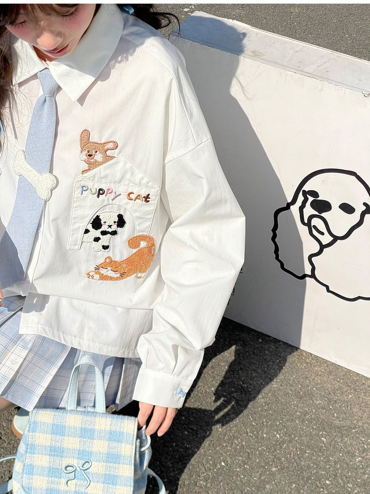 キティの青いネクタイとボーンパピーのアップリケがあしらわれた白いゆったりシャツ