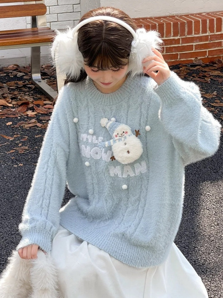 かわいい雪だるまが飾られた青いモヘアの柔らかいセーター