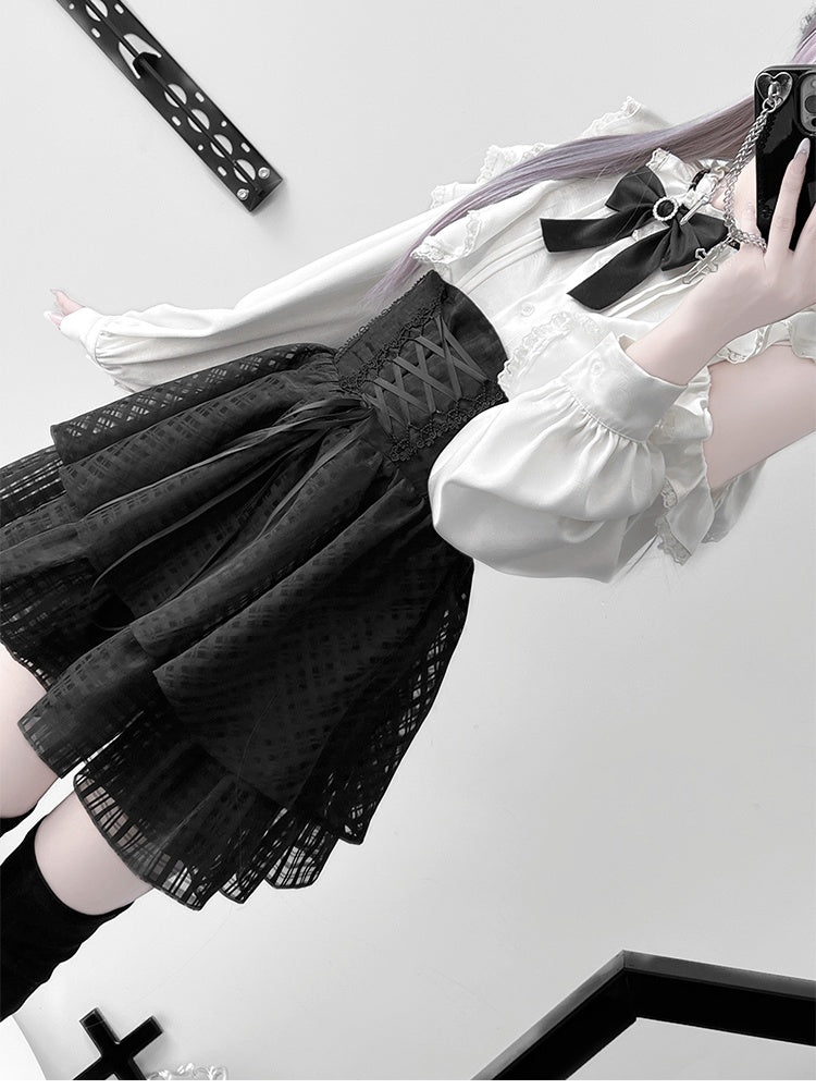 Ensemble Jirai Kei : chemisier blanc à volants et épaules découpées, jupe noire à volants et gros nœud