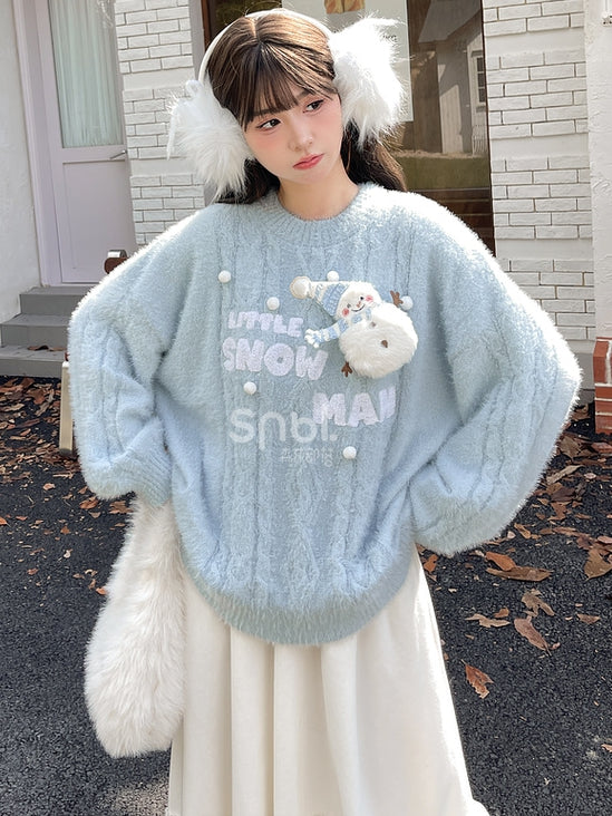 かわいい雪だるまが飾られた青いモヘアの柔らかいセーター