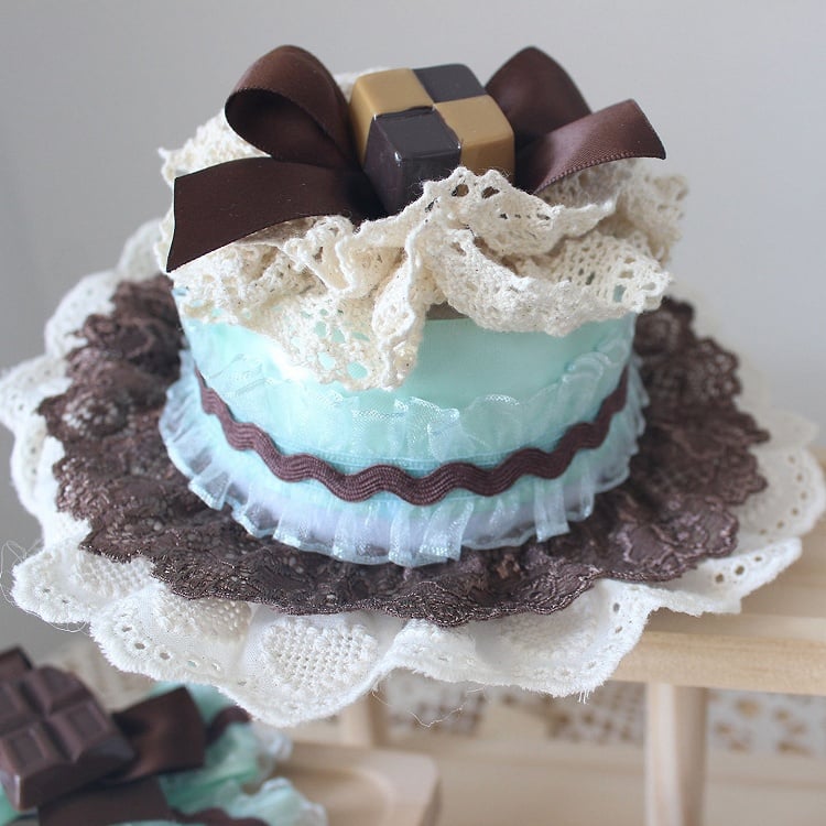 Grünbrauner Kuchenhut mit verzierter Schleife, Mini-Besatz, Schokoladenspitze