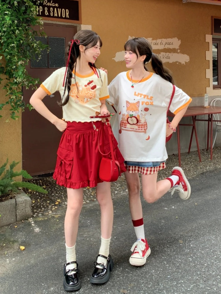 Gelbes T-Shirt mit Cartoon-Tierprint, Herzausschnitt und Apfelbrosche
