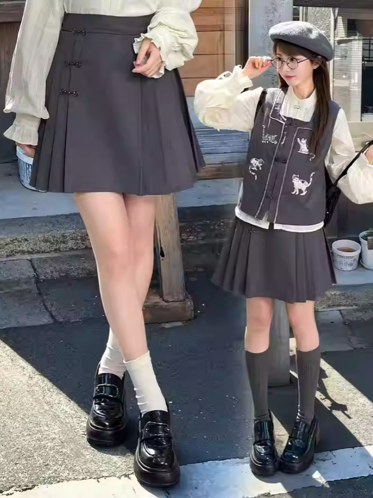 Grauer, oberschenkellanger Faltenrock mit Knotenknöpfen