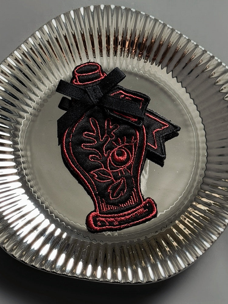 Schwarze Stickerei / Trankrote Brosche