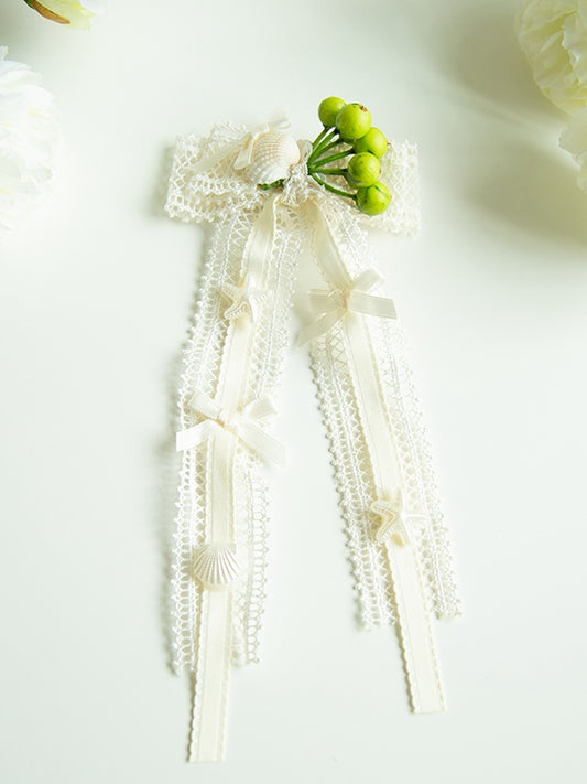 ヒトデの貝殻で飾られたブローチの蝶結びの海のクリーム