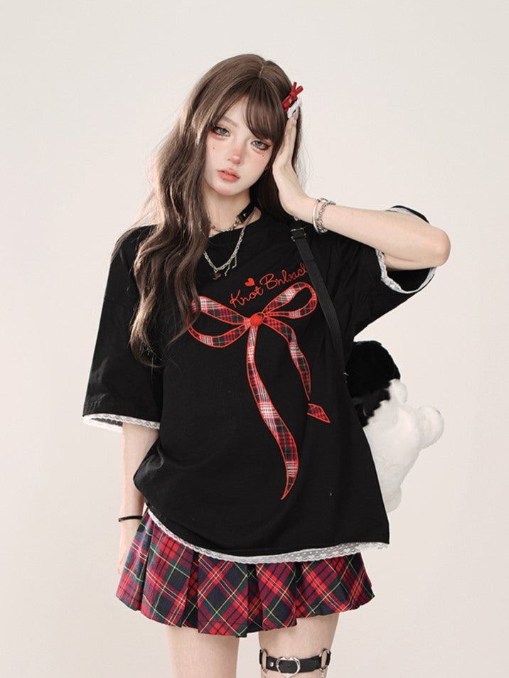 Schwarzes Oversize-T-Shirt mit Spitzenbesatz, gesticktem Schriftzug und kariertem Schleifenakzent