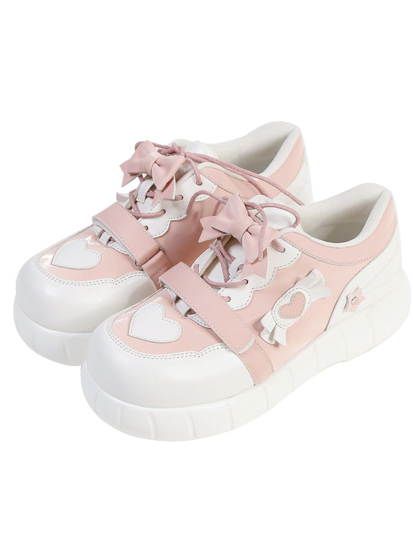 Rosa Sneakers und Akzente weiße Schleife