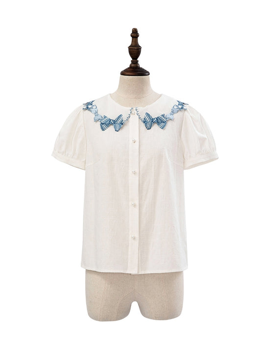 Blaue Bluse mit Schleifenbesatz und weißen Kurzarm