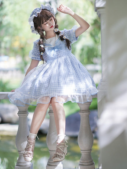 Robe à carreaux bleu clair à col marin et marguerites blanches, détails nœud papillon