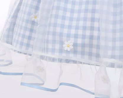 Robe à carreaux bleu clair à col marin et marguerites blanches, détails nœud papillon