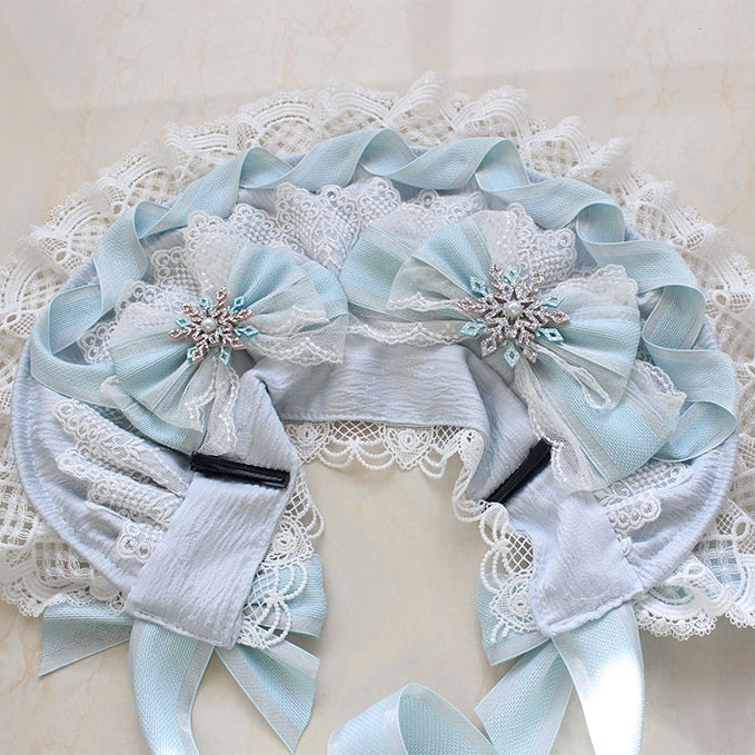 Bonnet bleu avec nœud papillon et bordure en dentelle décorée de perles et de neige