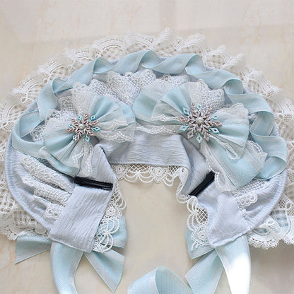 Bonnet bleu avec nœud papillon et bordure en dentelle décorée de perles et de neige