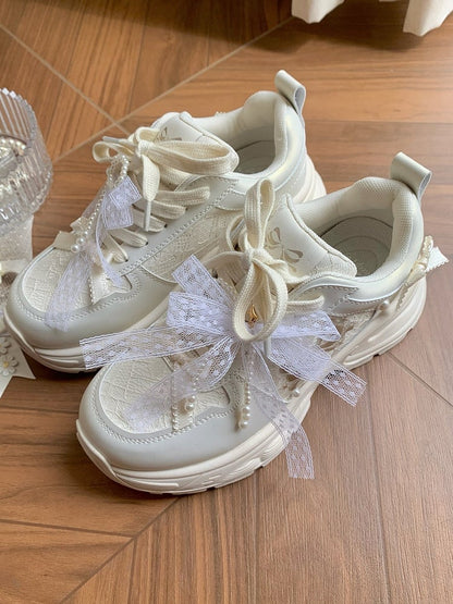 Schnürung vorne mit Schleife und weißen, mit Perlen verzierten Sneakers