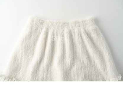 Jupe mi-longue beige taille haute avec détails en dentelle et ourlet à volants