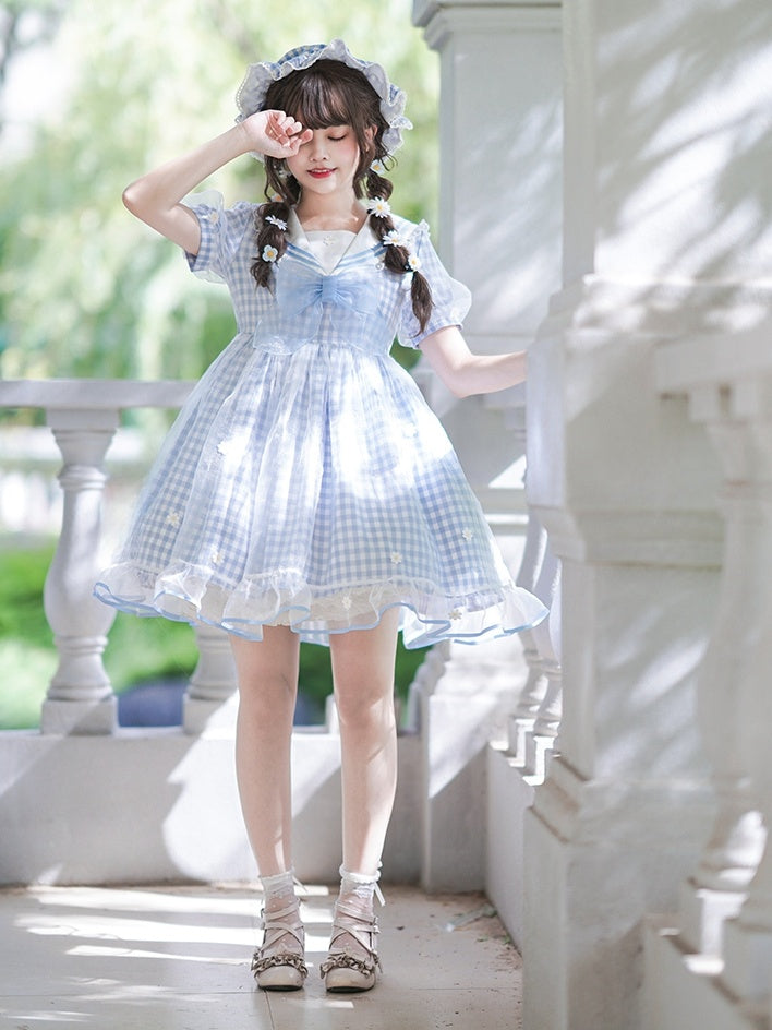 Robe à carreaux bleu clair à col marin et marguerites blanches, détails nœud papillon