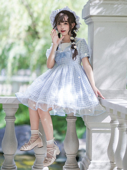 Robe à carreaux bleu clair à col marin et marguerites blanches, détails nœud papillon