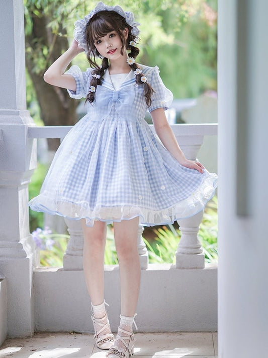 Robe à carreaux bleu clair à col marin et marguerites blanches, détails nœud papillon