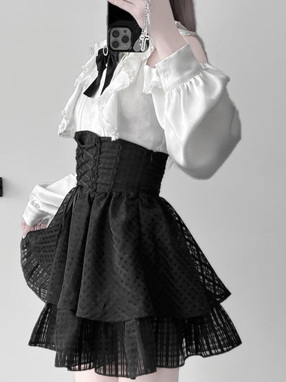 Ensemble Jirai Kei : chemisier blanc à volants et épaules découpées, jupe noire à volants et gros nœud
