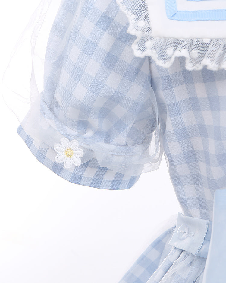 Robe à carreaux bleu clair à col marin et marguerites blanches, détails nœud papillon