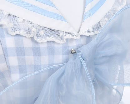 Robe à carreaux bleu clair à col marin et marguerites blanches, détails nœud papillon