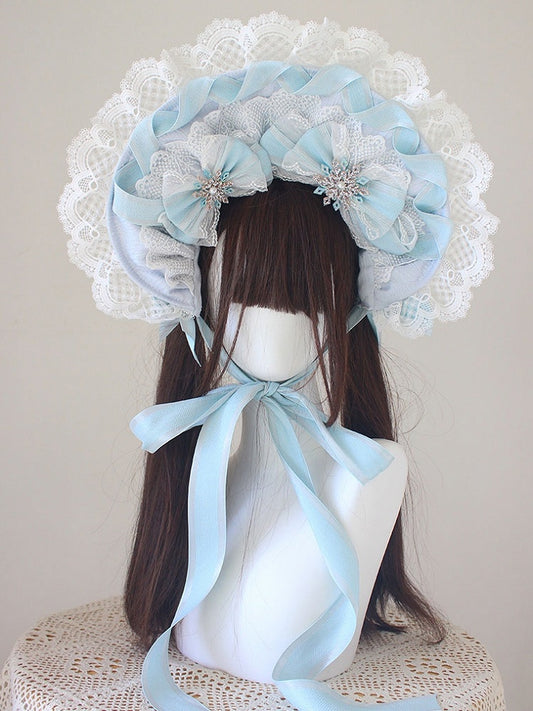 Bonnet bleu avec nœud papillon et bordure en dentelle décorée de perles et de neige