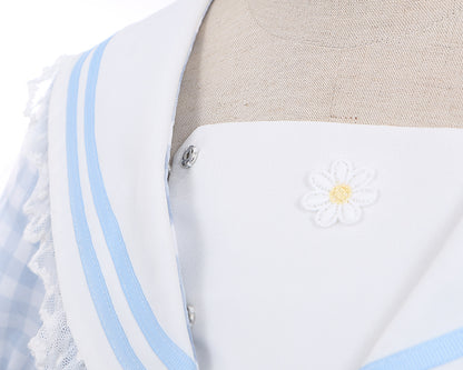 Robe à carreaux bleu clair à col marin et marguerites blanches, détails nœud papillon