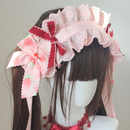 Bandeau rose avec détails de nœud papillon aux fraises et bordure en dentelle