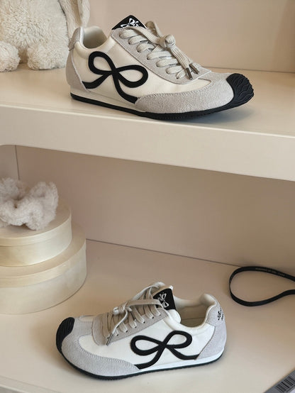 Weiße Sneakers mit Schnürung vorne und Schleife