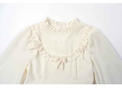 Robe à manches longues et col à volants avec nœud blanc