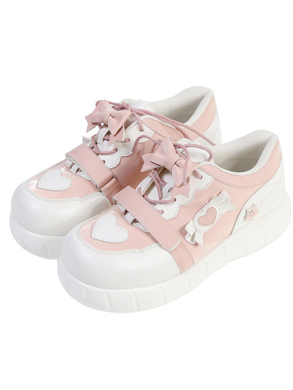 Rosa Sneakers und Akzente weiße Schleife